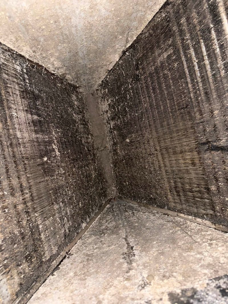 Corner of a duct run showing accumulated debris along the seam