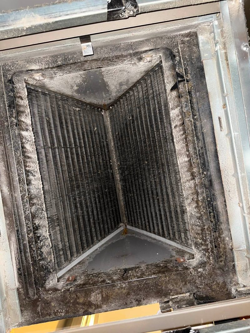 Rectangular sheet metal duct interior with built-up debris on the walls