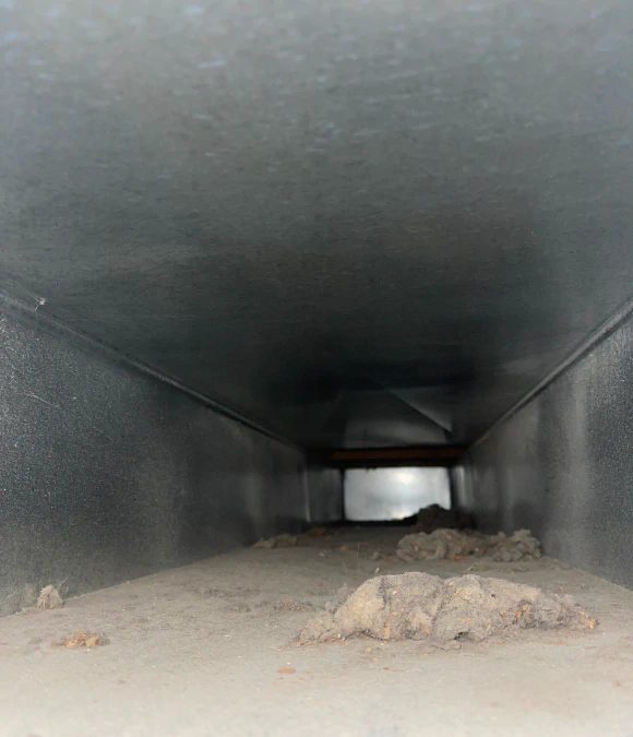 Large industrial duct trunk interior with settled debris