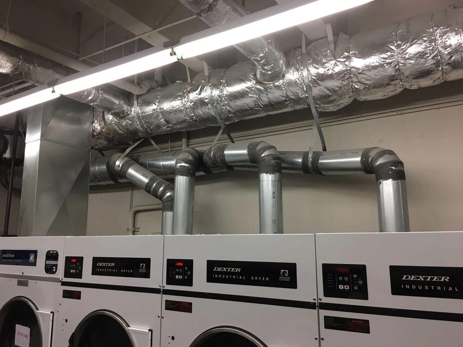 Row of commercial dryers in a shared laundry facility
